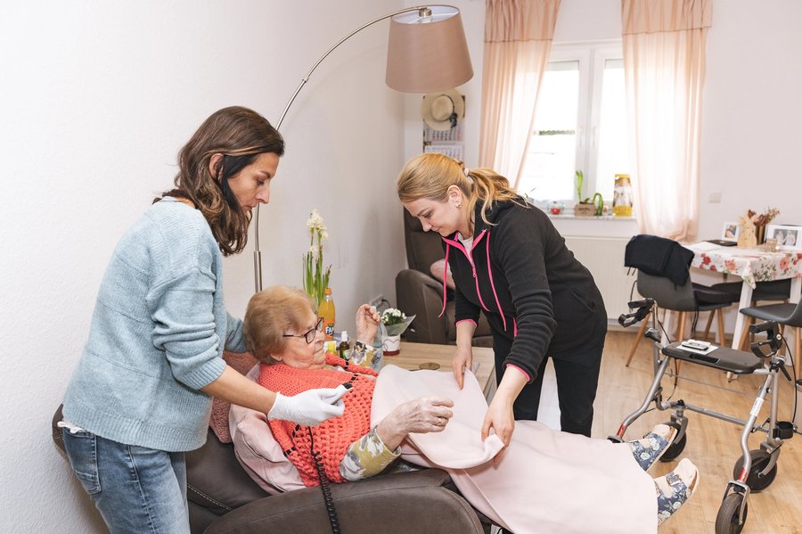 Zwei ARCHIMED-Pflegekräfte versorgen gemeinsam einen Patienten zu Hause